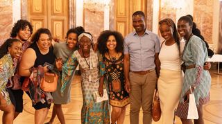 Weltweiter Startschuss der „Schwarzen Akademie“ im Mannheimer Schloss: In der Bildmitte im türkis gemusterten Kleid steht Projektleiterin Nicole Amoussou.