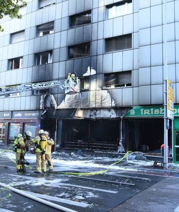 Einsatzkräfte der Feuerwehr vor dem Brandort.