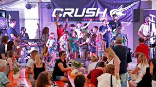 Die Band Crush rockt bei der Kerwe in Wallstadt das Festzelt und holt auch immer wieder Kinder auf die Bühne, die mit aufblasbaren Gitarren „mitspielen“ dürfen.