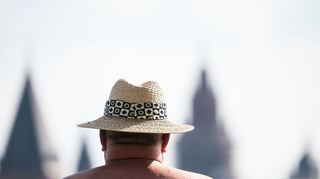 Es ist heiß in Deutschland: Ein Mann am Rheinufer mit Blick auf den Mainzer Dom.