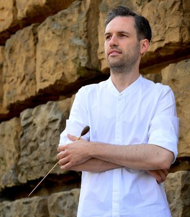 Imposant posiert vor den Steinen des Mannheimer Wasserturms: EYOA-Dirigent Jan-Paul Reinke.