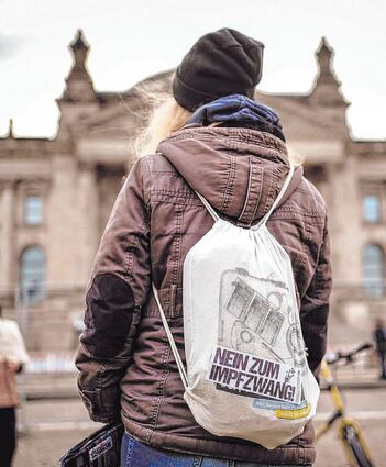 Eine Demonstrantin protestiert vor dem Reichstagsgebäude gegen eine Impfpflicht.