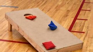 Bei Cornhole müssen Säckchen auf ein Brett geworfen werden.