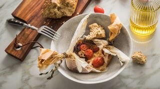 Feta mit Kirschtomaten lässt sich auch in Backpapier grillen.