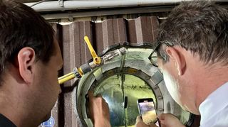 Staatssekretär Baumann (r.) und Landwirt Jürgen Schaaff werfen einen Blick in den Gärbehälter der Biogasanlage.