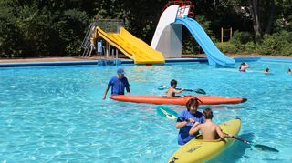 Eine besondere Attraktion des Schwimmbadfestes: Kanufahren im Becken. Aktive des Kanu-Clubs Rheinau helfen, das Gefährt zu steuern.