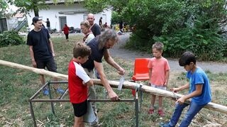 Die Ferienspielkinder waren einen Tag auf dem Areal der Pfadfinder zu Gast, hier schälen sie die Rinde einer Robinie ab.