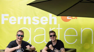 Das Schlager-Duo DJ Robin (r) & Schürze, die Interpreten des Liedes «Layla», sitzen im "ZDF-Fernsehgarten" auf der Bühne. Seit Wochen gibt es eine Sexismus-Debatte um ihr Lied. Der «Fernsehgarten» stand am Sonntag unter dem Partymotto «Mallorca vs. Oktoberfest». +++ dpa-Bildfunk +++