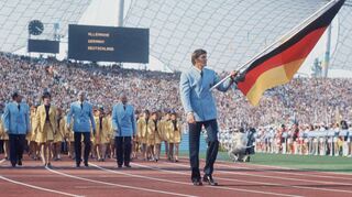 Der deutsche Kanute Detlef Lewe führt die deutsche Mannschaft als Fahnenträger vor 50 Jahren ins Olympiastadion.