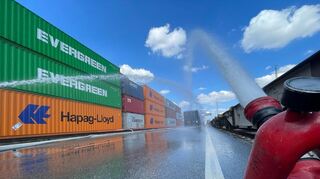 Die Feuerwehr pumpt Wasser auf den Container im Mannheimer Mühlauhafen.