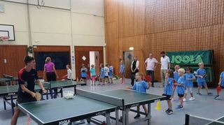 In der Nordbadenhalle üben Frederik Probst und Massimo Mulay mit den Kindern die Grundtechniken des Tischtennis.