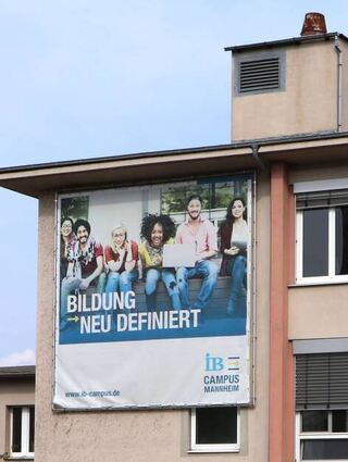 Auf einer Fassade in Richtung Neckarauer Straße hängt noch ein einsames Plakat, das für den Campus wirbt.