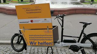 Bestückt mit Informationsmaterial macht das Lastenrad des Grundbildungszentrums an der Abendakademie in den Stadtteilen und der Innenstadt Station.