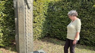 Iris Tusche blickt auf die Namenstafel an der Gedenkstele. Sie verlor bei dem Unglück ihren Ehemann.
