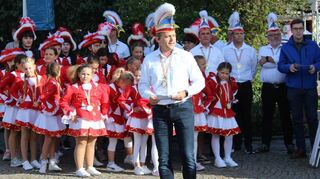 Volker Hildebrand moderiert die Eröffnung der Kerb. Im Hintergrund stehen die Tanzgruppen des HCV sowie Erster Stadtrat Marius Schmidt (rechts).