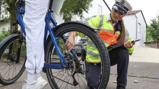 Die Polizeibeamtin überprüft bei diesem Fahrrad die Bremsen. Auf der Mängelliste werden diese oft neben der Beleuchtung und der Klingel aufgeführt.