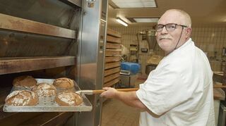Gregor Gebhardt holt in seiner Bäckerei in Bürstadts Nibelungenstraße das Brot aus dem Ofen.