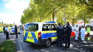 Die Einsatzkräte begutachten den Polizeiwagen, der mit einer Radfahrerin zusammenstieß.