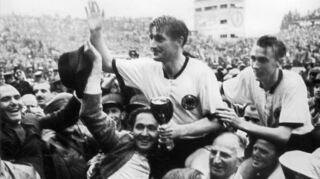 Horst Eckel (rechts) und Fritz Walter nach dem WM-Sieg von Bern 1954, als sie von begeisterten Anhängern vom Spielfeld getragen wurden.