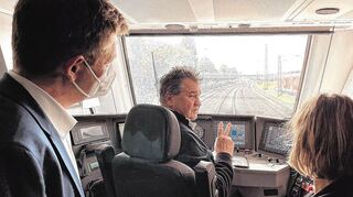 Bahnchef Richard Lutz (l) und Umweltministerin Katrin Eder (r) lassen sich während der Fahrt nach Neustadt den neuen Akkuzug vom Lokführer erklären.