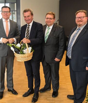 Wein und einen Schokolade-Wasserturm als Dankeschön (v.l.): Torbjörn Kartes, Günther Oettinger, Claudius Kranz und Christian Hötting beim Festakt der CDU zum Tag der Deutschen Einheit.