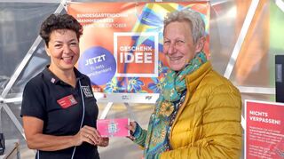 Bettina Schorb (l.) verkauft die erste Tageskarte der Bundesgartenschau an Heike Konrad.
