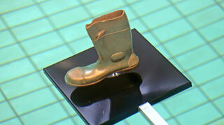 Goldener Stiefel als Symbol für die Wegwerfgesellschaft.