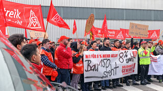 „8 Prozent oder die Tonne brennt“: Beschäftigte von Daimler Truck streiken vor Tor 2 in Mannheim.
