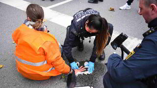 Polizei-und Rettungskräfte lösten den Kleber und entfernten die Aktivistinnen und Aktivisten von der Straße.