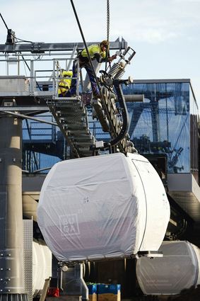Arbeiter befestigen auf dem Gelände der Bundesgartenschau Seilbahn-Kabinen. Die Buga findet von April bis Oktober 2023 in Mannheim statt.