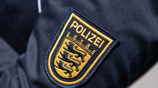 Das Wappen der Polizei Baden-Württemberg ist auf der Uniform einer Polizeibeamtin zu sehen.