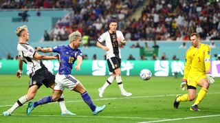 Takuma Asano (M) von Japan setzt sich gegen Nico Schlotterbeck (l) von Deutschland durch und erzielt das 2:1.