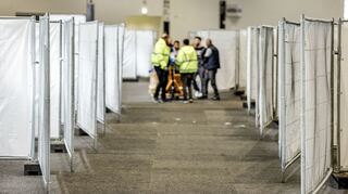Arbeiter bereiten eine Messehalle in Hamburg für die Unterbringung von Schutzsuchenden aus der Ukraine vor.