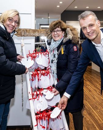 Weiße Herzen für die Aktion „Wünsche(weiter)Leiter“ für Senioren: Menschen in Heimen, die keine Angehörigen mehr haben, können Wünsche notieren, die von Bür-gern erfüllt werden. OB Stefanie Seiler (v.l.), Bürgermeisterin Monika Kabs und Michael Schmitt vom Herrenmodegeschäft, in dem die Leiter steht, greifen zu.