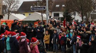Die Kinder der Gerhart-Hauptmann-Schule in Nikolausmontur – einer der Auftritte, die Siedlerchef Hans Held (links mit grüner Mütze) ansagen kann.
