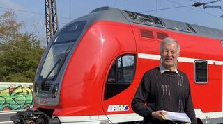 Am Ladenburger Bahnhof mit dem Faltplan der Bus- und Bahnverbindungen: Der Ladenburger Bahnexperte Axel Juedtz im April 2021.