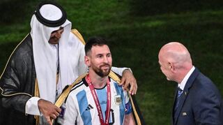 Unrühmliche Instrumentalisierung: Der Emir von Katar, Scheich Tamim bin Hamad Al Thani (li.), legt Argentiniens Lionel Messi vor der Übergabe des WM-Pokals und vor FIFA-Präsident Gianni Infantino ein „Bischt“ an.