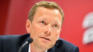 Sportmanager Jan-Axel Alavaara von den Adler Mannheim sitzt bei einer Pressekonferenz auf dem Podium.