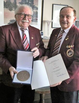 Karl Wowy (v.l.), Vorsitzender des Chors, und der Präsident des Deutschen Fleischer Sänger Bundes, Berthold Bissinger, mit der Zelter-Plakette.