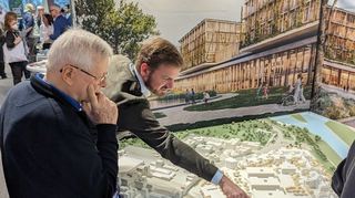Paul Engelbrecht (r.), Bauleiter im Geschäftsbereich Bau und Technik des Universitätsklinikums, zeigt interessierten Besuchern beim Neujahrsempfang das Modell der „Neuen Mitte“.