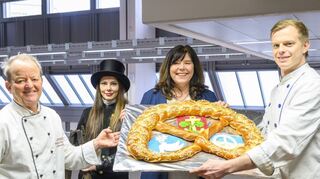 Innungs-Bäckermeister Ulf Lanzet (v.l.), Schornsteinfegermeisterin Jessica Kovacs, Oberbürgermeisterin Jutta Steinruck und Bäcker Sebastian Lanzet bei der Übergabe der Neujahrsbrezel.