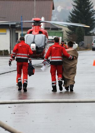 <p>Feuerwehrmänner begleiten am 26.11.2012 in Titisee-Neustadt (Baden-Württemberg) vor einer Behindertenwerkstatt einen Verletzten. 14 Menschen sind bei dem Brand ums Leben gekommen. Foto: Patrick Seeger/dpa +++(c) dpa - Bildfunk+++</p>
