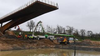 Oben der Panoramasteg, unten Arbeiten unter dem Grundwasserspiegel: Per Betonpumpe wird die Masse zur Abdichtung des Augewässers aufgetragen.