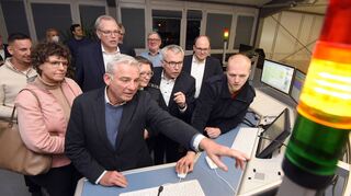 Innenminister Thomas Strobl zeigt interessiert auf einen Bildschirm der Leitstelle, Regierungspräsidentin Felder (l.) schaut ihm über die Schulter.