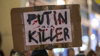 Eine Demonstrantin hält in Berlin ein Plakat mit der Aufschrift „Putin is a Killer“ (Putin ist ein Mörder).