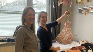 Tanja Richtberg (l.) ist seit wenigen Wochen Zweifach-Mama. Hebamme Karolin Huschak ermittelt mit der Hängewaage das Gewicht des Babys.