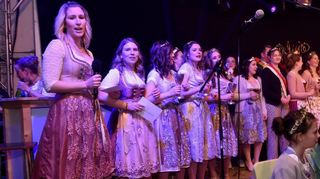 Fulminantes Finale des Krönungsabends: Alle Hoheiten auf der Bühne, links die beiden Moderatorinnen Lisa Menges und Sophie Koch. vorne die drei kleinen Prinzessinnen.