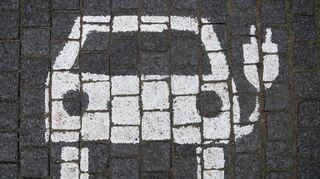Ein Symbol markiert einen Parkplatz mit einer öffentlichen Ladesäule für Elektroautos in der Innenstadt.