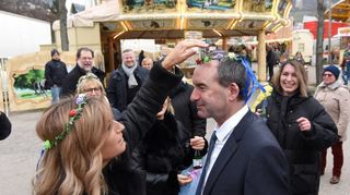 Von feiernden Besucherinnen auf dem Festplatz wird der Minister spontan gekrönt.