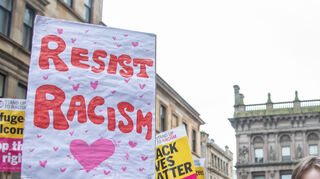Ein Schild auf einer Demo gegen Rassismus, hier in Schottland, die im Hinblick auf den Internationalen Tag zur Beseitigung rassistischer Diskriminierung stattfand.
